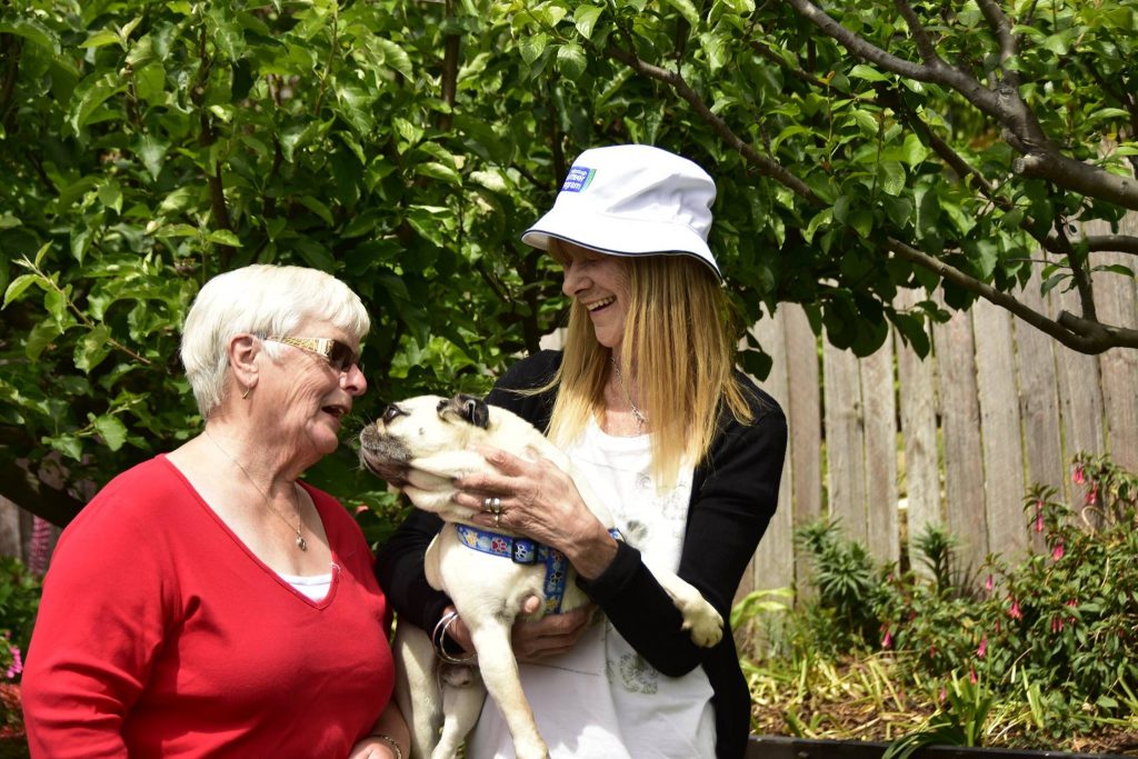 Photo of volunteer with client and dog
