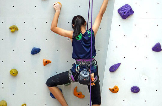 Photo of girl indoor rock climbing