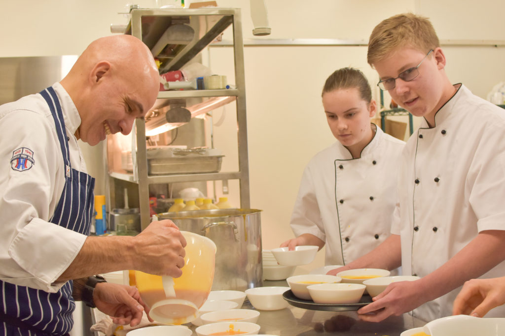 Photo of chef teaching youth how to make and serve lunch