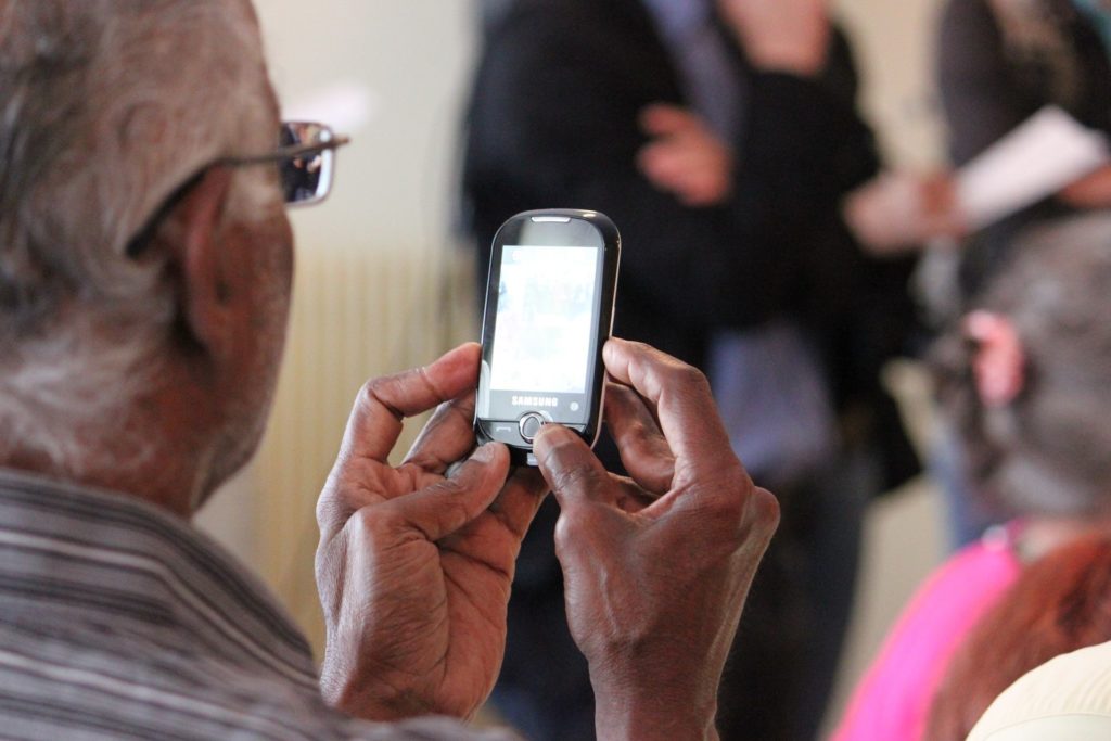 Photo of older man looking at a mobile phone